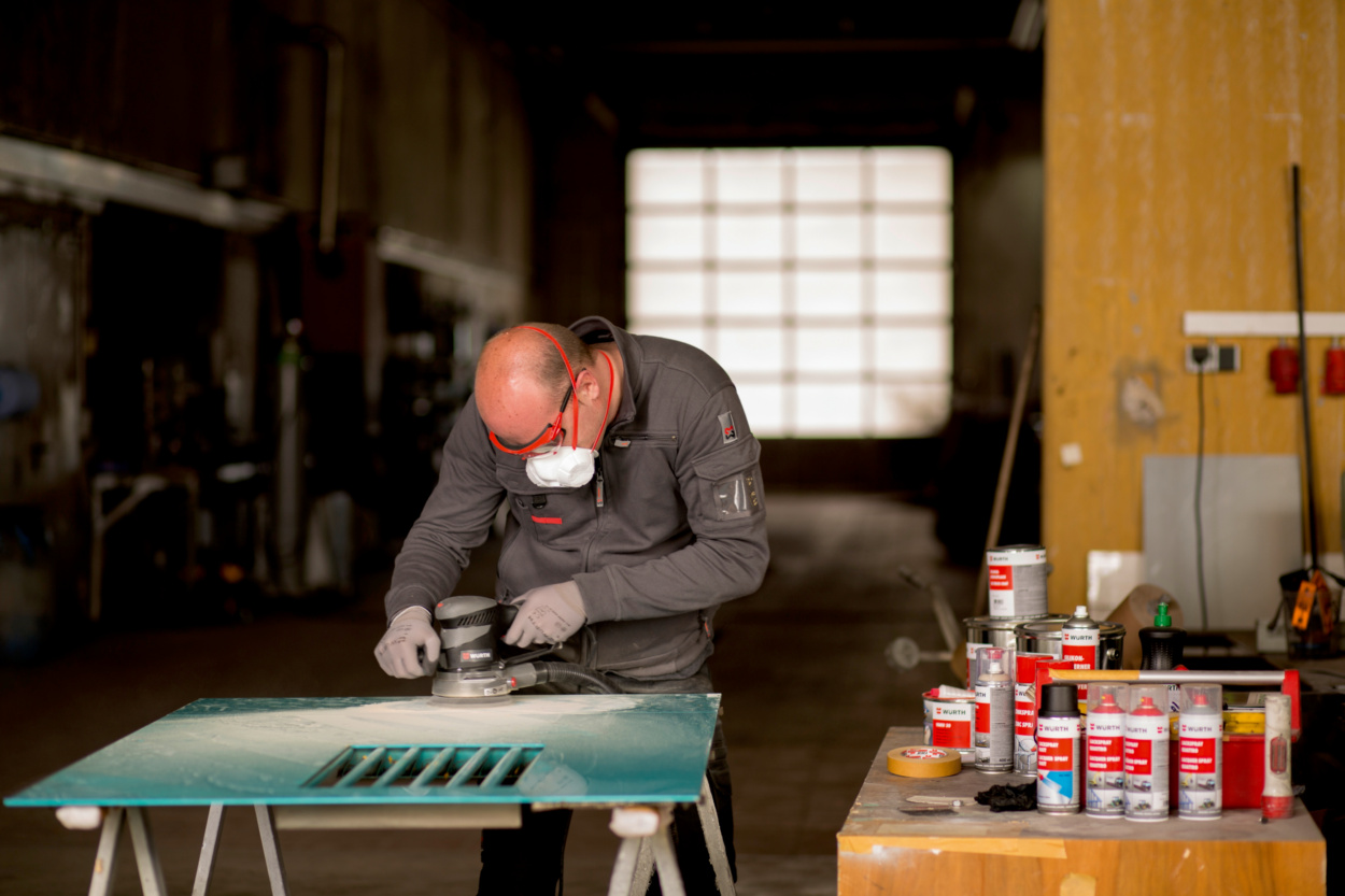 Abschleifen einer Lackschicht mit Exzenterschleifer für Vorbereitung der Reparaturlackierung